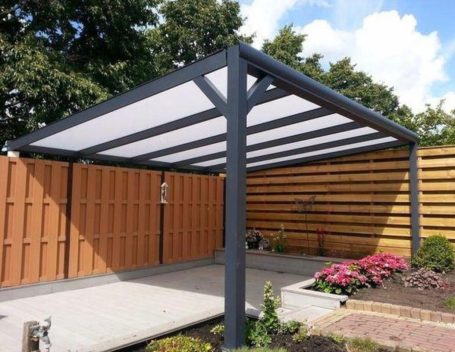 Moderne overkapping met een wit doek en houten omheining in een tuin